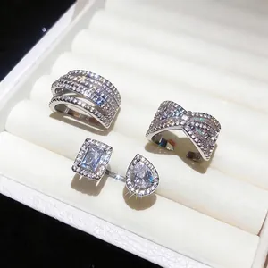 Elegant zircon criss-cross and bow rings displayed in a white luxury jewelry box