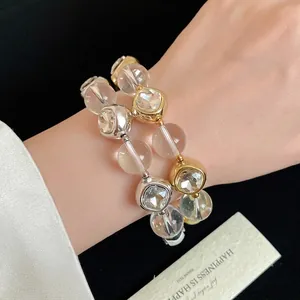 Fashionable gold and silver beaded bracelet set with clear faceted crystals on wrist