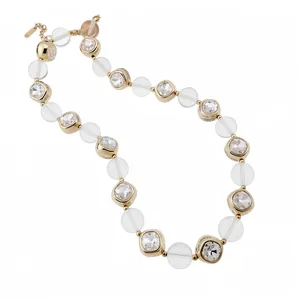 Elegant gold necklace featuring square cut crystals and frosted white beaded accents
