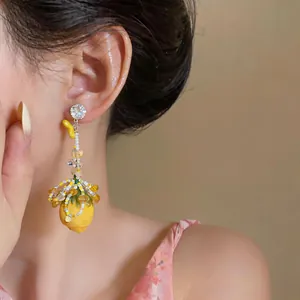 Close-up of elegant silver needle earring with yellow flower and crystal drop tassel