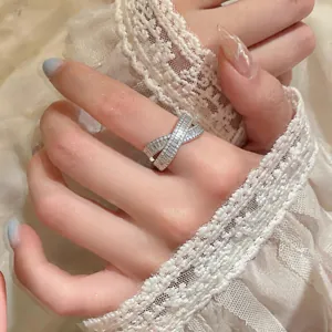 Close-up of elegant silver-toned criss-cross X ring with sparkling zircon pavé