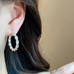 Eleganti orecchini a cerchio ritorti in argento dal design minimalista e alla moda.
