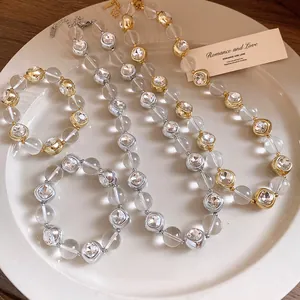 Close-up of elegant clear bead necklaces and bracelets with rhinestone accents.