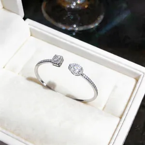 Detail showing elegant silver open ring with emerald and pear-cut cubic zirconia stones