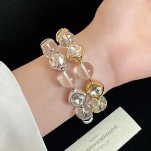 Close-up of elegant gold and silver beaded bracelets with sparkling crystals on wrist