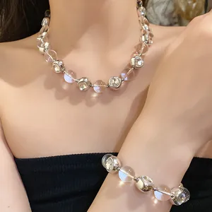 Close-up of elegant silver beaded necklace and bracelet with clear crystals on a model