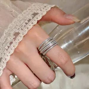 Detailed view of an elegant silver zircon cross X-shaped ring worn on a finger
