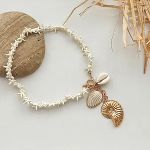 Detailed view of bohemian starfish necklace with golden shell and nautilus charms