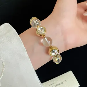 Close-up of a crystal beaded bracelet with gold-toned rhinestone accents on a wrist
