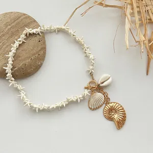 Detail view of Bohemian starfish bead necklace with golden shell charms and toggle clasp
