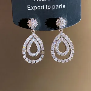 Orecchini a doppia goccia con zirconi, placcatura in oro 18K e eleganti perni a fiore