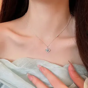 Elegant silver-tone necklace with a zircon-encrusted flower pendant worn on a model