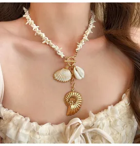 Elegant Bohemian shell and starfish beaded choker necklace with gold pendants worn by a model