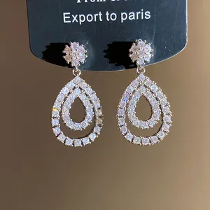 Primo piano di eleganti orecchini a goccia in zircone con design a doppio cerchio.
