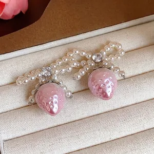 Sweet pink pearl strawberry bowknot stud earrings displayed in a luxury jewelry box