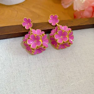 Dettaglio di orecchini vintage francesi con fiori in smalto rosa e bordo oro