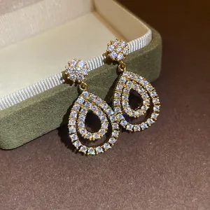 Dettaglio di orecchini a goccia placcati in oro 18K con pietre di zircone trasparente