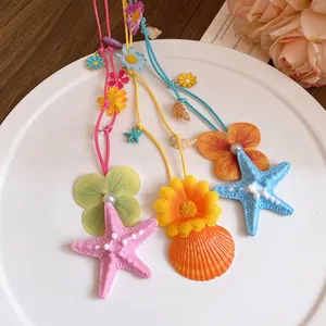 Seaside vacation style necklace with colorful starfish, shells and artificial flower pendants.