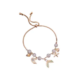 Gold chain bracelet featuring grey beads and ocean-themed charms like mermaid tail