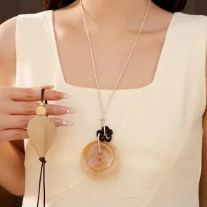 Collier élégant avec pendentif en acrylique, fleur et cordon en cuir de couleur crème