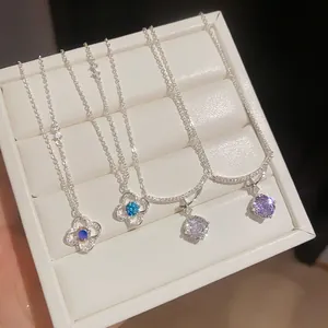 Selection of silver zircon flower and star necklaces displayed in a white jewelry case.