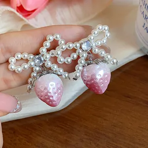 Sweet pearl bow knot earrings featuring pearlescent pink strawberry charms for women