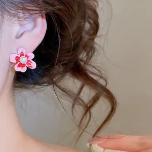 Primo piano dell'orecchino a fiore rosa stile pittura a olio con perla su modella