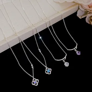 Detailed view of four silver pendant necklaces featuring sparkling cubic zirconia stones