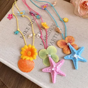 Close-up detail of colorful starfish and shell necklaces with vibrant fabric flower accents