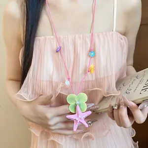 Detailed view of a colorful starfish and flower charm necklace for beach vacation style.