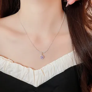 Macro view of a silver necklace with a delicate purple zircon flower pendant.