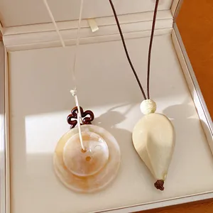 Détail de colliers avec pendentif ethnique en acrylique et cordon dans un coffret