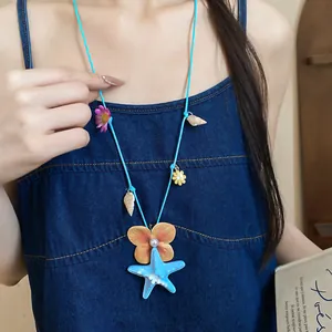 Detail view of a vibrant starfish and shell necklace worn by a model for beach vacations.