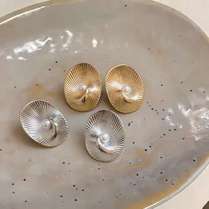 Macro view showing the detailed texture and pearl center of gold and silver earrings