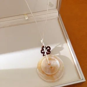 Vue détaillée en gros plan du pendentif bouton en acrylique marbré et décor floral