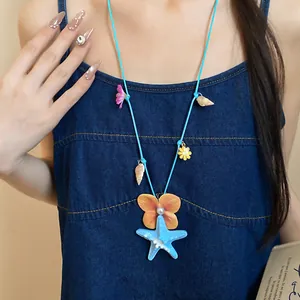 Detailed view of beach-themed necklace with blue starfish, shells and flower charms