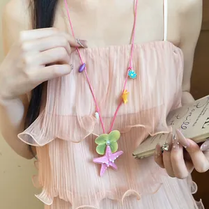 Close-up of beach vacation style necklace with pink starfish and flower charms