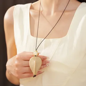 Vue détaillée du collier avec pendentif goutte de style ethnique sur cordon minimaliste