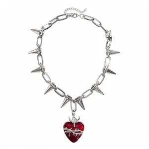 Collana punk gotica con catena d'argento, punte in metallo e ciondolo a cuore rosso.