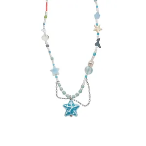 Beach style beaded necklace with shell and starfish charms, white background
