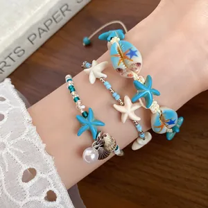 Close-up detail of beach vacation style starfish and shell beaded bracelets on a wrist