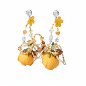 Boucles d'oreilles pendantes fleurs en tissu jaune avec zircone et perles fines.