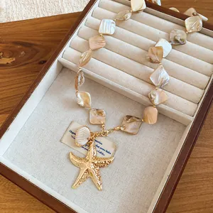 Detail view of seaside vacation necklace with irregular shells and starfish charm