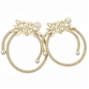 Ornate gold-tone dangling earrings with sparkling crystals and elegant white pearl drops