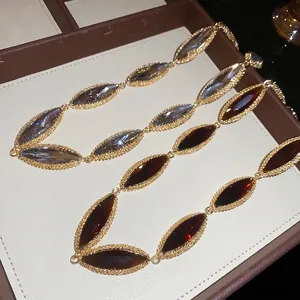 Elegant marquise-shaped crystal link necklace with gold-tone textured borders in two colors