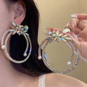 Detailed close-up of oversized rhinestone hoop earrings featuring pearl and floral crystal accents
