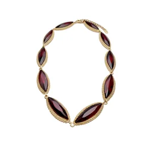 Luxurious gold-tone collar necklace featuring marquise-cut deep red faceted crystals.