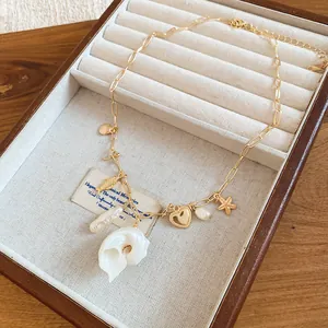 Detailed view of beach style necklace with irregular shell, starfish and heart charms