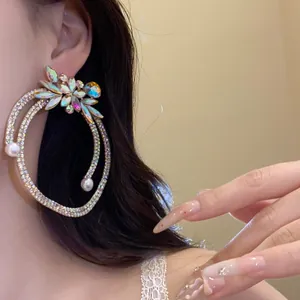 Detailed close-up showing luxurious vintage rhinestones and pearl hoop earrings worn on a model's ear