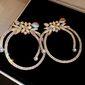 Close-up detail of oversized crystal hoop earrings with iridescent floral stones and pearls